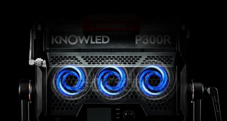 Верхняя часть задней панели осветителя Godox KNOWLED P300R на черном фоне с сотовой решеткой активного охлаждения, графическими вихрями потоков воздуха и антенной CRMX